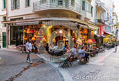 Atmospheric scene of people sitting at an Athens cafeteria late Editorial Stock Photo