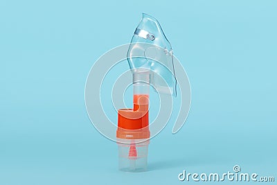 Atomizing cup with respiratory mask for nebulizer on blue Stock Photo