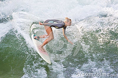 Atractive sporty girl in neoprene shorty wave surfing. Stock Photo