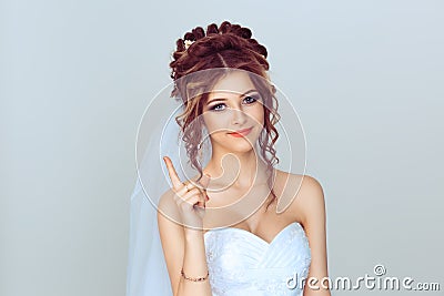 Attention listen to me. Close up portrait of young bride spouse woman showing attention be careful hand gesture isolated on light Stock Photo