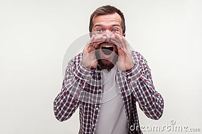 Attention! Portrait of enraged mad bearded man yelling loudly holding arms around mouth. white background Stock Photo