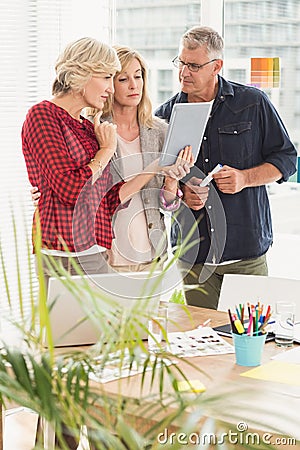 Attentive business team looking at digital tablet Stock Photo