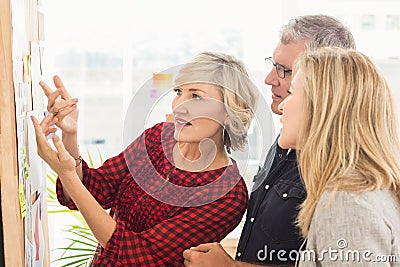 Attentive business team looking at notes on the wall Stock Photo