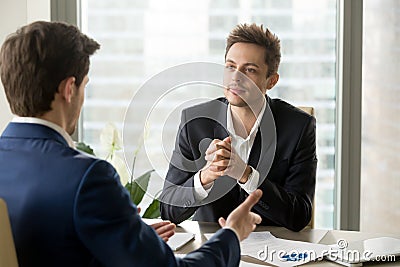 Attentive businessman listening to business partner talking duri Stock Photo