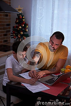 Attentive and careful father help son to study Stock Photo