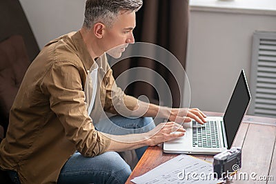 Attentive man looking at laptop with interest Stock Photo