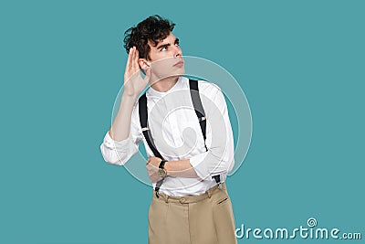 Attentive man trying to hear with hand near ears Stock Photo