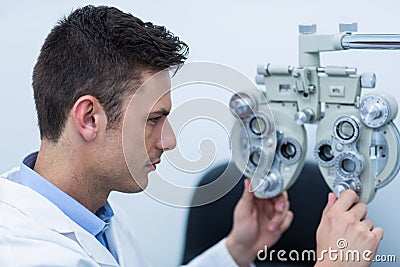 Attentive optometrist adjusting phoropter Stock Photo