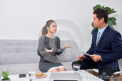 Attentive psychologist. Attentive psychologist holding pencil in his hands making written notes while listening to his client Stock Photo