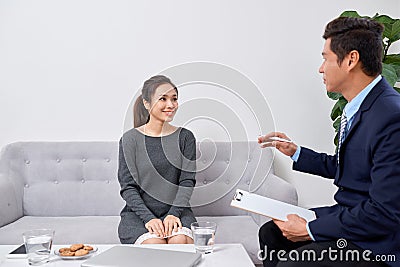 Attentive psychologist. Attentive psychologist holding pencil in his hands making written notes while listening to his client Stock Photo