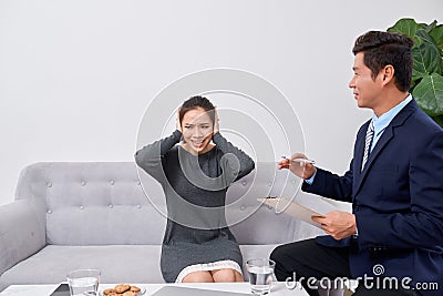 Attentive psychologist. Attentive psychologist holding pencil in his hands making written notes while listening to his client Stock Photo