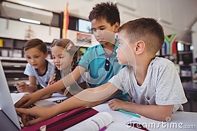 Attentive schoolkid using laptop in library Stock Photo