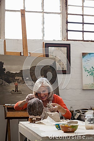 Attentive senior woman making a clay sculpture Stock Photo