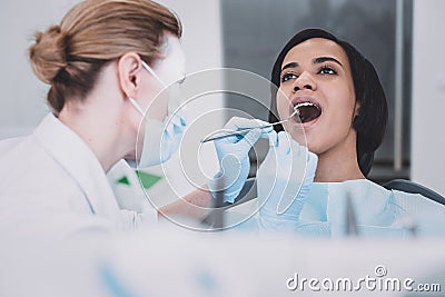 Attentive young professional stomatologist doing teeth checkup Stock Photo