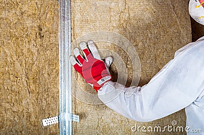 Attic loft insulation by hand Stock Photo