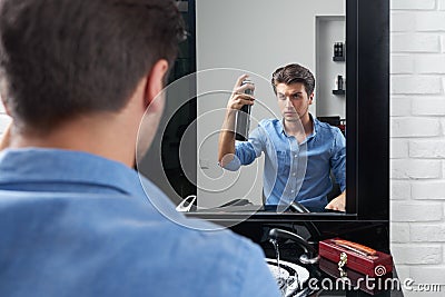 Attntive man is making hairdo and pulverize spray Stock Photo