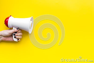 Attract attention concept. Megaphone in hand on yellow background top view copy space Stock Photo