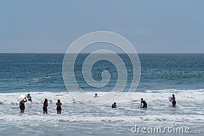 Attracted by the huge crowds at the Zuma Beach in Malibu, California, on the Memorial Day, a small pod of dolphins gets close to t Editorial Stock Photo