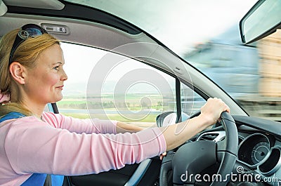 Attractive adult woman safe carefully driving car suburban road Stock Photo