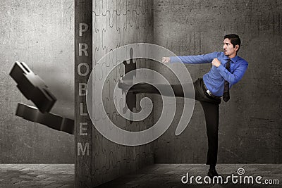 Attractive asian businessman kicking puzzle piece with problem s Stock Photo