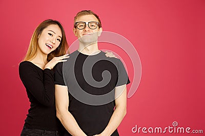 Attractive asian and caucasian inter racial hugging in studio sh Stock Photo
