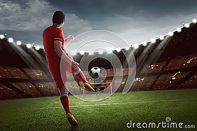 Attractive asian football player shooting the ball to goal Stock Photo