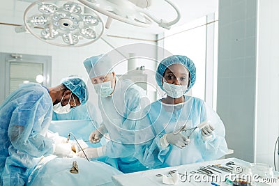 Attractive assistant using scissors while performing operation Stock Photo