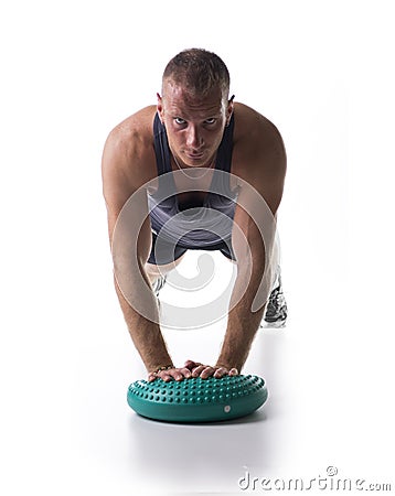 Attractive athletic young man working out with balance board Stock Photo