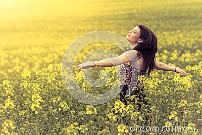 Beautiful woman in meadow of yellow twist from behind Stock Photo