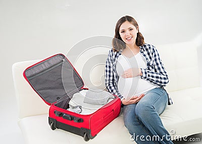 Attractive awaiting woman packing children's clothes Stock Photo