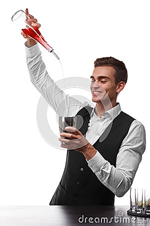 An attractive bartender at a bar counter doing a cocktail, a plate of lime isolated on a white background. Stock Photo