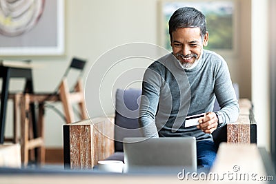 Attractive bearded hipster asian father or Hispanic old man using Laptop and credit card payment shopping online with customer Stock Photo