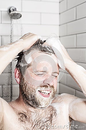 Bearded man washing her hair in the shower under running water. Stock Photo