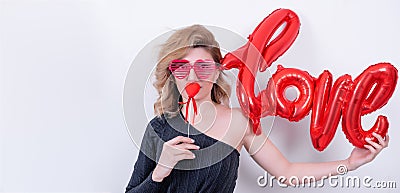 Woman holds love word shaped red balloon Stock Photo