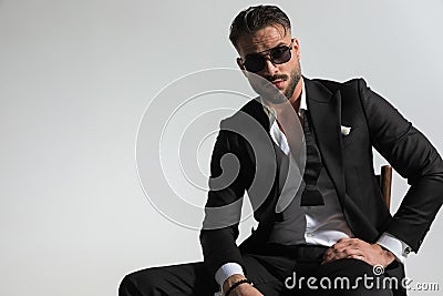 Attractive best man with undone shirt in black tuxedo posing Stock Photo