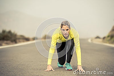 Attractive blond sport woman ready to start running practice training race starting on asphalt road mountain landscape Stock Photo