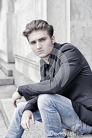 Attractive blond young man sitting outdoors Stock Photo