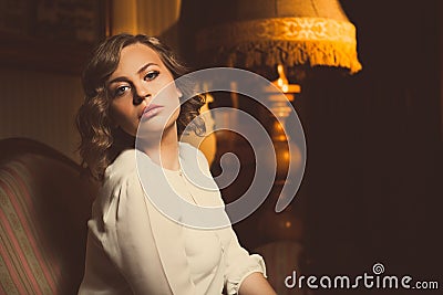 Attractive blonde woman dramatic portrait in luxurious room.Beautiful film noir woman.Beautiful sensual innocent woman in whi Stock Photo