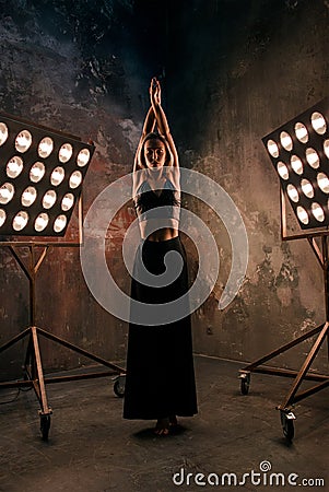 Attractive blonde young woman dancer on the stage with lights in loft background Stock Photo