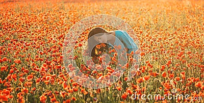Attractive woman sniffing a poppy in field. Stock Photo