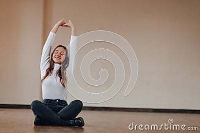 Attractive business-style girl sits on the floor in a lotus position. yoga in the office, relaxation at work. search for harmony Stock Photo