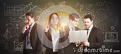 Attractive businesspeople with laptop working together on chalkboard wall background with business sketch. Training, workshop and Stock Photo