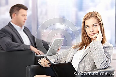 Attractive businesswoman sitting in office lobby Stock Photo