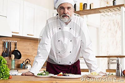 Attractive Caucasian chef standing in a restaurant kitchen Stock Photo