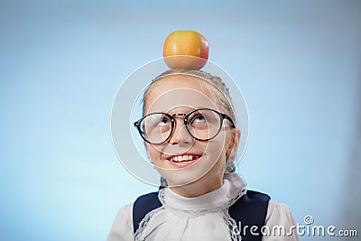 Attractive Caucasian Girl With Apple On Blue Background. Schoolgirl Smiling. Happy Child With Fresh Fruit - Emotional Portrait Stock Photo