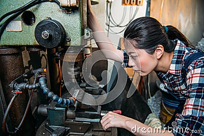 Factory female staff adjust industrial machines Stock Photo