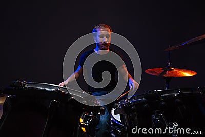 Attractive concentrated bearded man drummer playing his kit Stock Photo