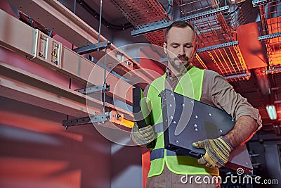 attractive concentrated technician in safety vest Stock Photo