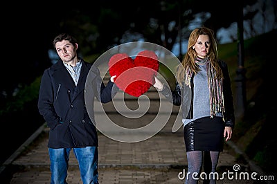 Attractive couple fighting over a love heart pillow Stock Photo