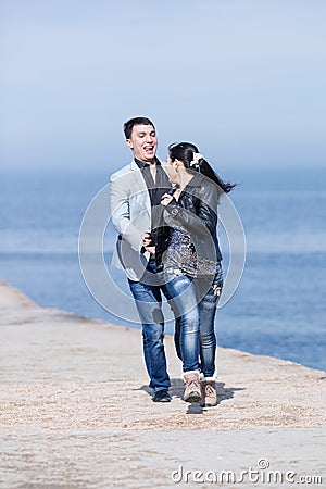 Attractive couple running along of pier Stock Photo